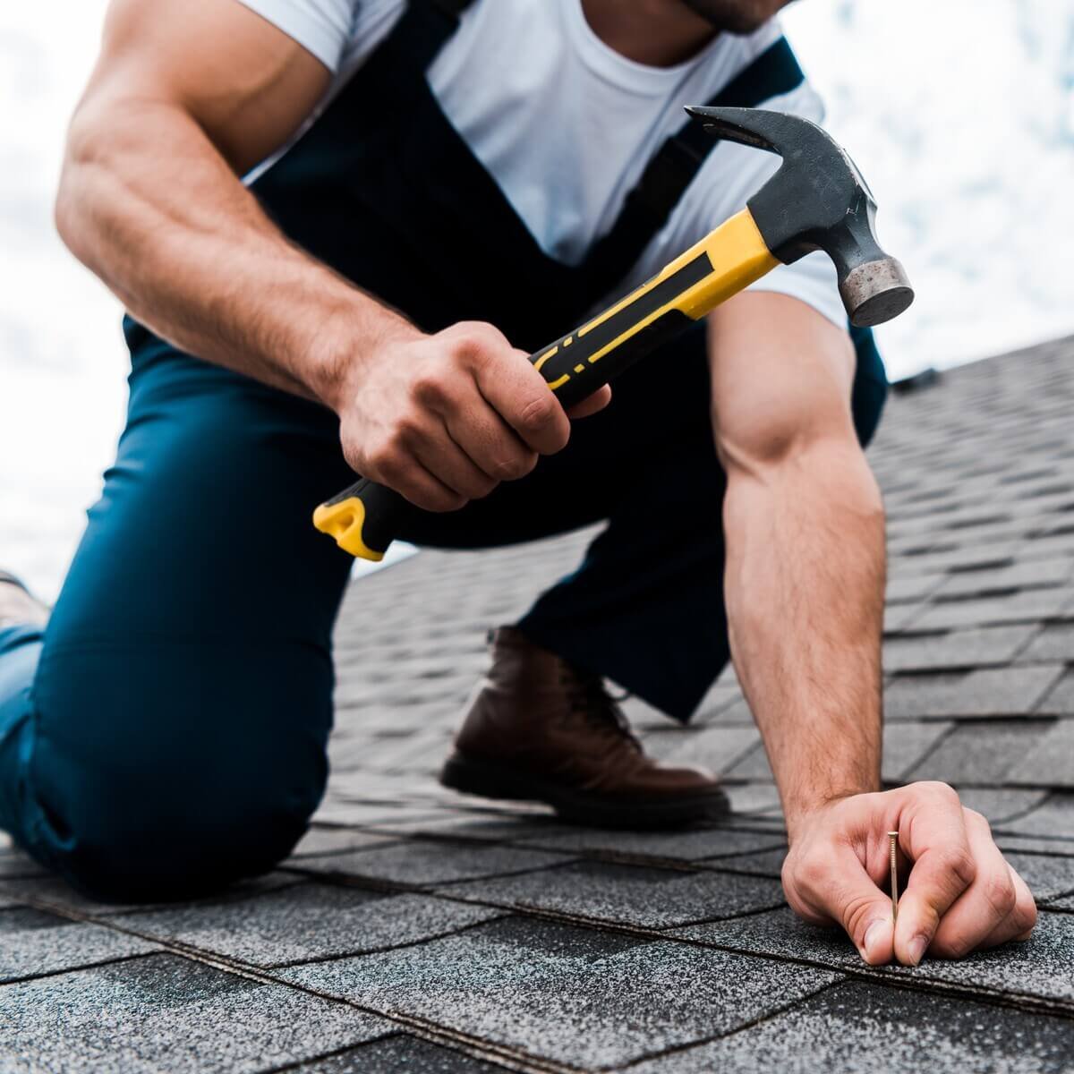 cropped-view-of-handyman-in-uniform-holding-hammer-FM77ZCC.jpg